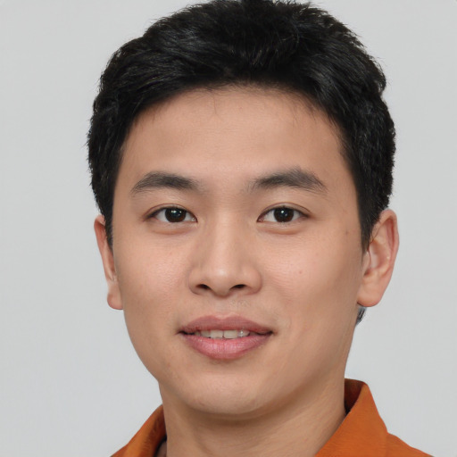 Joyful asian young-adult male with short  black hair and brown eyes