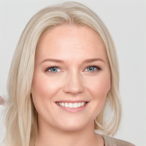 Joyful white young-adult female with long  blond hair and blue eyes