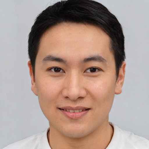 Joyful asian young-adult male with short  brown hair and brown eyes