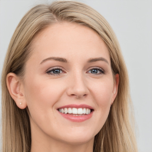 Joyful white young-adult female with long  brown hair and blue eyes