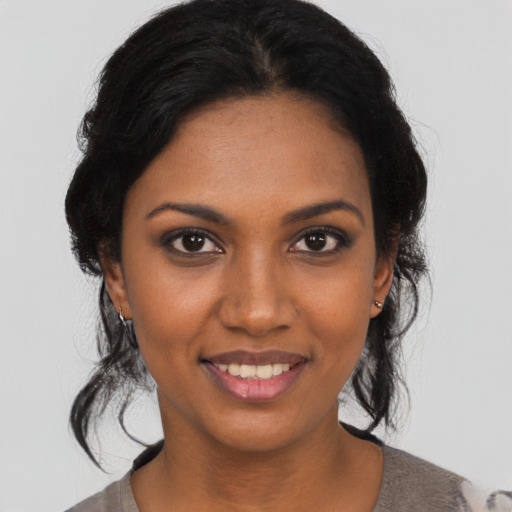 Joyful black young-adult female with medium  brown hair and brown eyes