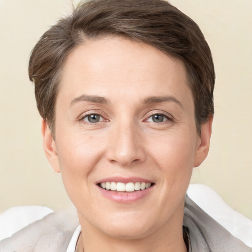 Joyful white young-adult female with short  brown hair and grey eyes