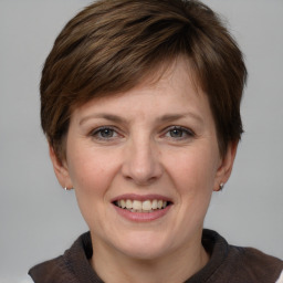 Joyful white young-adult female with medium  brown hair and grey eyes