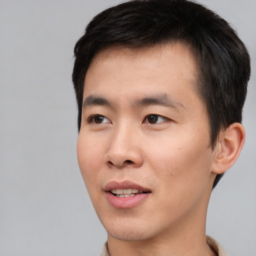 Joyful asian young-adult male with short  black hair and brown eyes