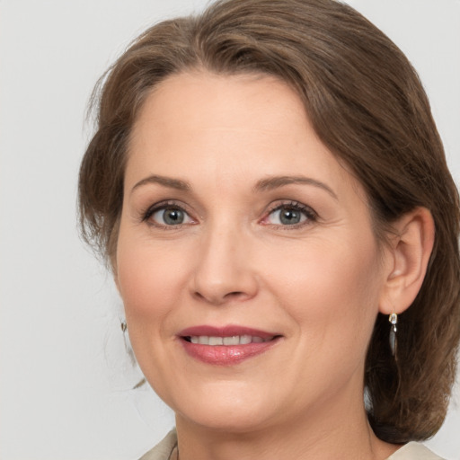 Joyful white adult female with medium  brown hair and grey eyes