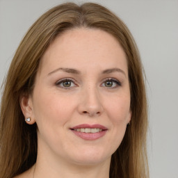 Joyful white adult female with long  brown hair and green eyes