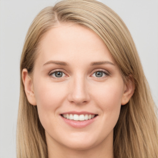 Joyful white young-adult female with long  brown hair and blue eyes