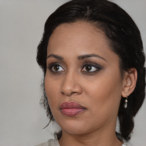 Joyful black young-adult female with medium  brown hair and brown eyes