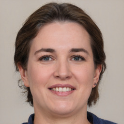 Joyful white adult female with medium  brown hair and grey eyes