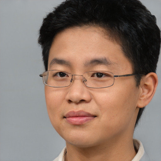 Joyful asian young-adult male with short  brown hair and brown eyes
