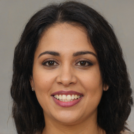 Joyful latino young-adult female with long  brown hair and brown eyes