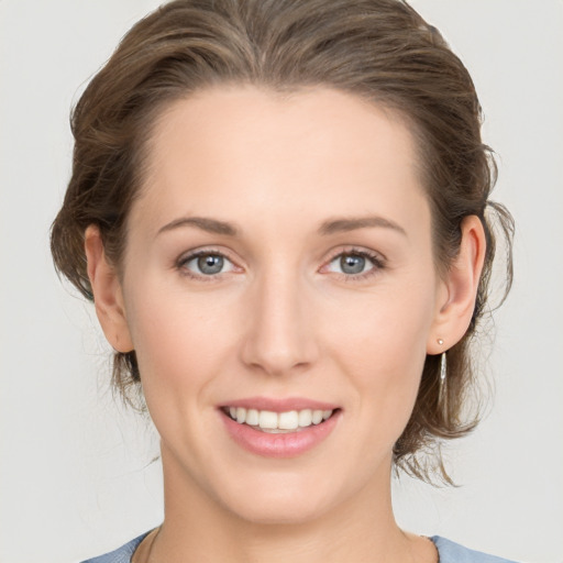 Joyful white young-adult female with medium  brown hair and grey eyes