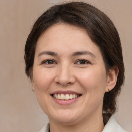 Joyful white adult female with medium  brown hair and brown eyes