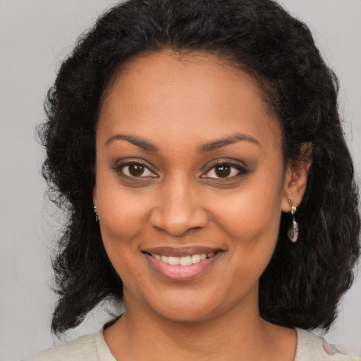 Joyful black young-adult female with medium  brown hair and brown eyes