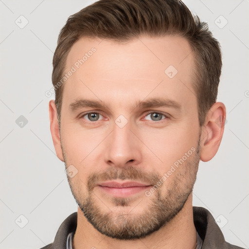 Joyful white young-adult male with short  brown hair and grey eyes