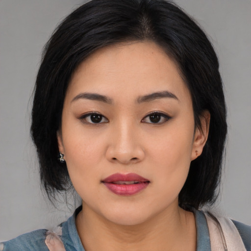 Joyful asian young-adult female with medium  black hair and brown eyes