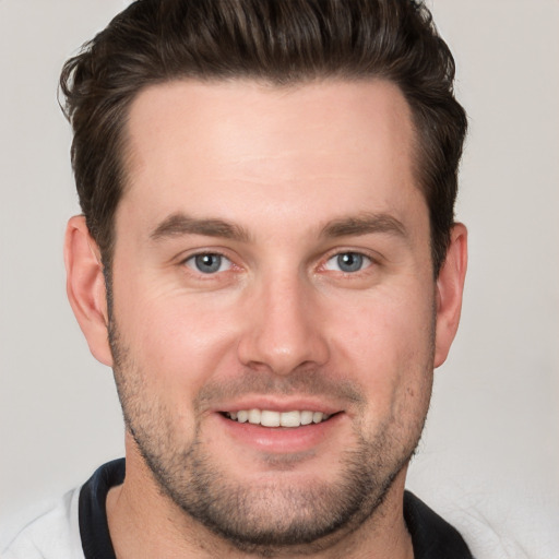 Joyful white young-adult male with short  brown hair and grey eyes