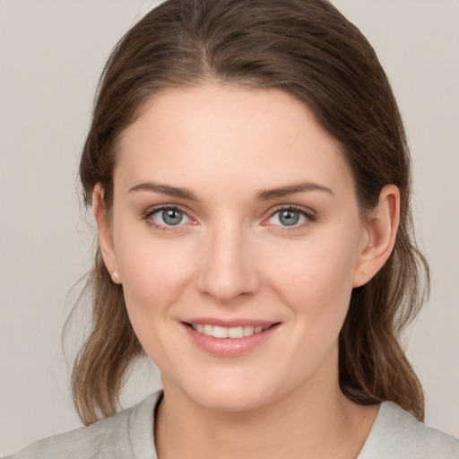 Joyful white young-adult female with medium  brown hair and grey eyes