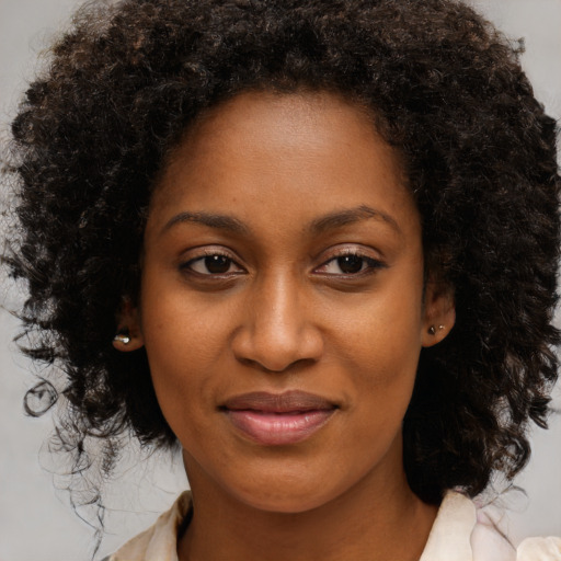 Joyful black young-adult female with medium  brown hair and brown eyes
