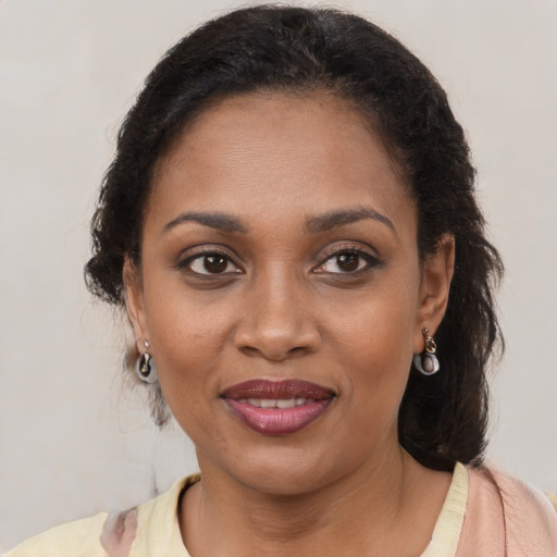 Joyful black young-adult female with long  brown hair and brown eyes