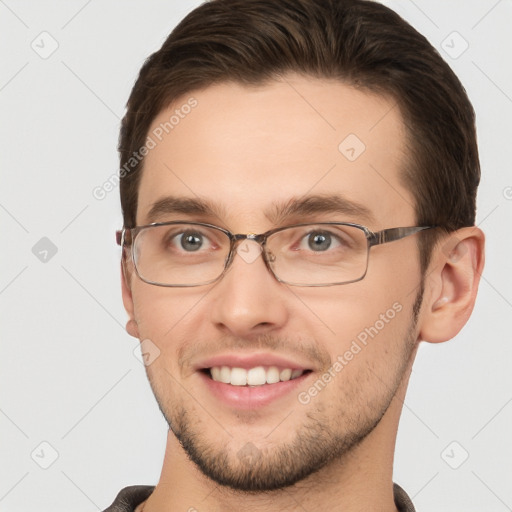 Joyful white young-adult male with short  brown hair and grey eyes