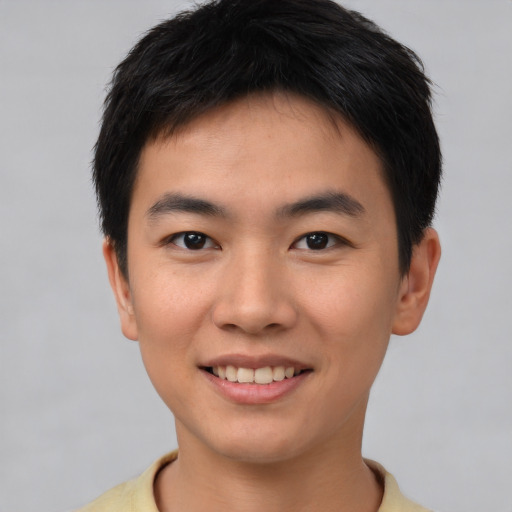 Joyful asian young-adult male with short  brown hair and brown eyes