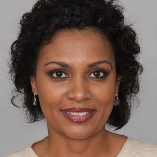Joyful black young-adult female with medium  brown hair and brown eyes