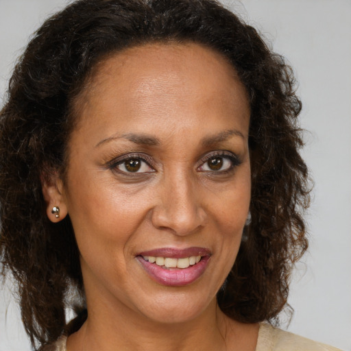 Joyful black adult female with medium  brown hair and brown eyes