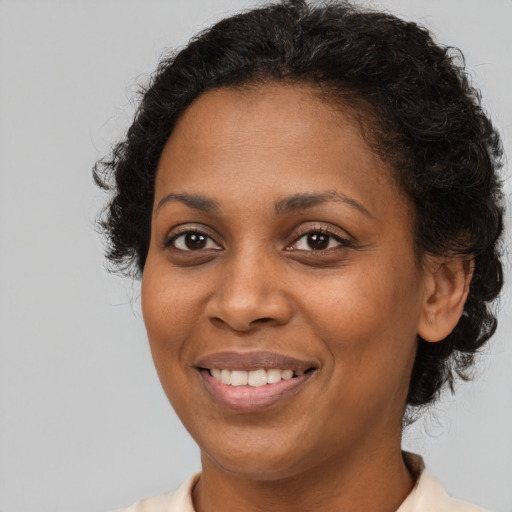 Joyful black young-adult female with short  brown hair and brown eyes