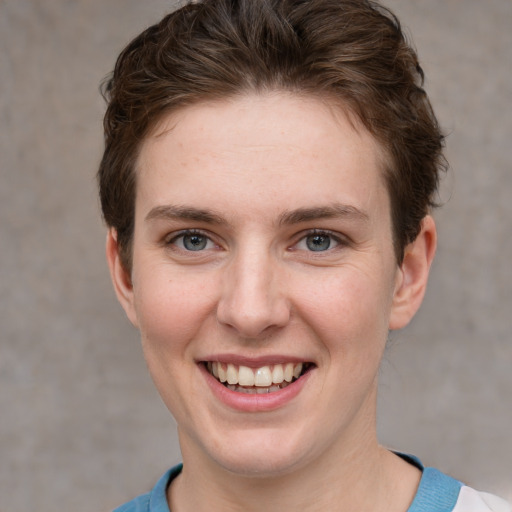 Joyful white young-adult female with short  brown hair and grey eyes