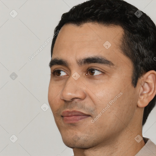 Joyful white young-adult male with short  black hair and brown eyes