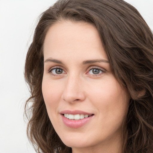 Joyful white young-adult female with long  brown hair and green eyes