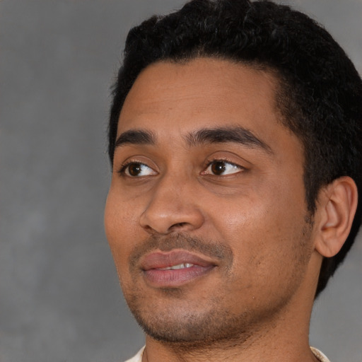 Joyful black young-adult male with short  black hair and brown eyes