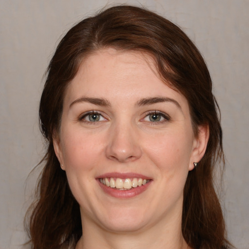 Joyful white young-adult female with medium  brown hair and grey eyes