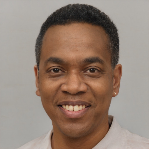 Joyful black adult male with short  black hair and brown eyes