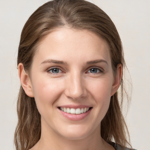 Joyful white young-adult female with medium  brown hair and grey eyes