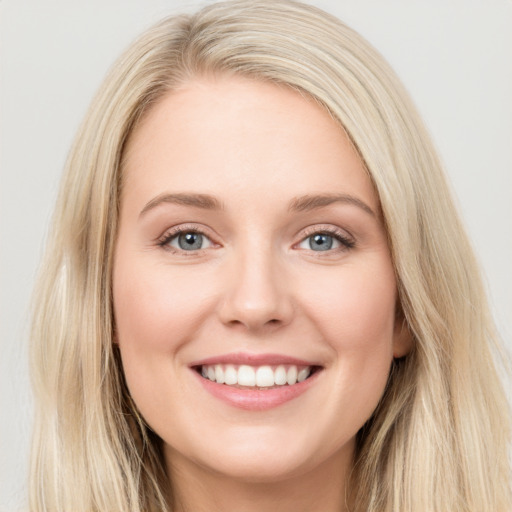 Joyful white young-adult female with long  brown hair and blue eyes