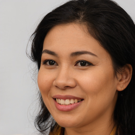 Joyful asian young-adult female with long  brown hair and brown eyes