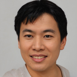 Joyful asian young-adult male with short  black hair and brown eyes