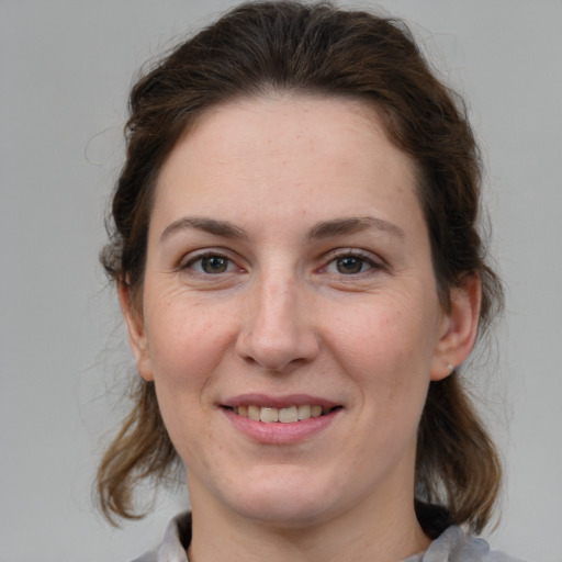 Joyful white adult female with medium  brown hair and grey eyes