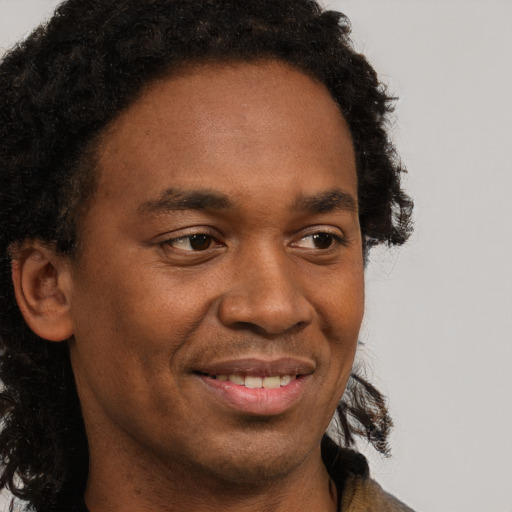 Joyful black young-adult male with short  brown hair and brown eyes
