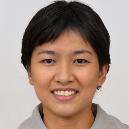Joyful asian young-adult female with short  brown hair and brown eyes