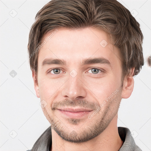 Joyful white young-adult male with short  brown hair and grey eyes