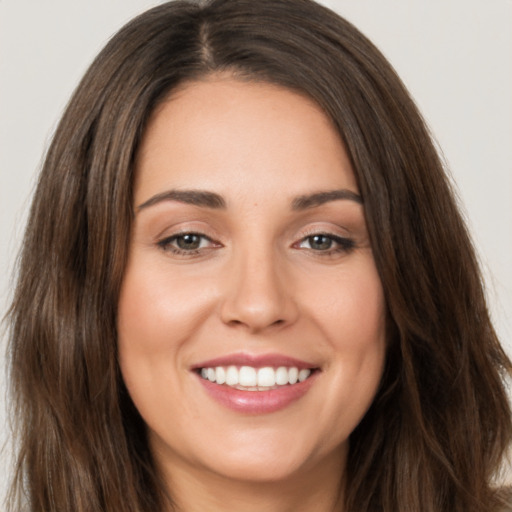 Joyful white young-adult female with long  brown hair and brown eyes