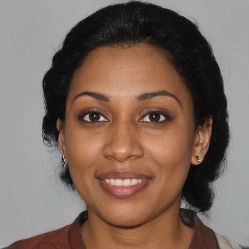 Joyful black young-adult female with medium  black hair and brown eyes