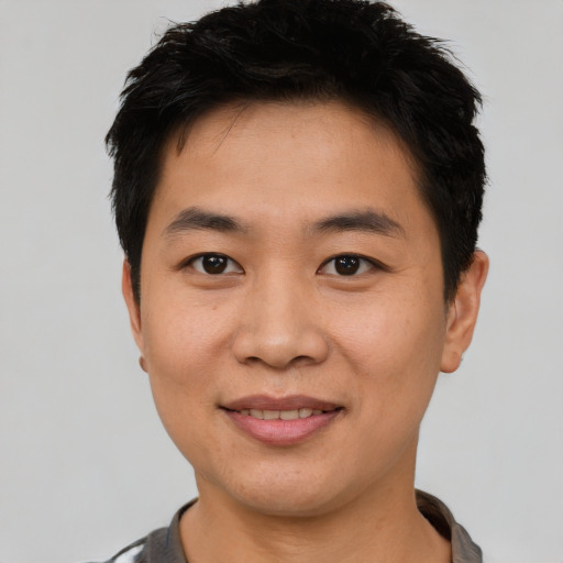 Joyful asian young-adult male with short  black hair and brown eyes