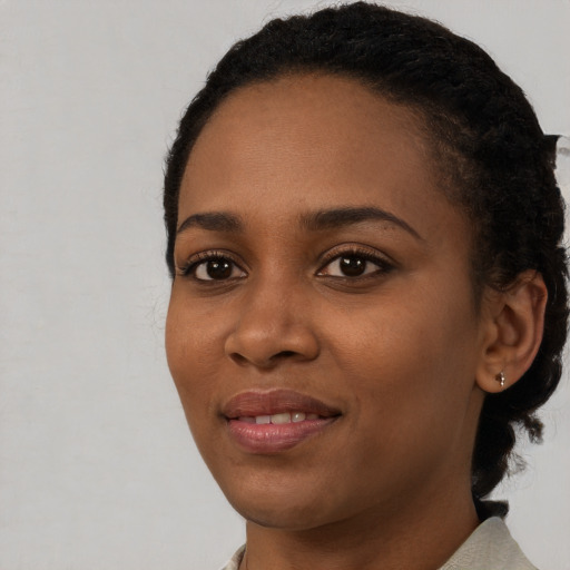 Joyful black young-adult female with short  black hair and brown eyes