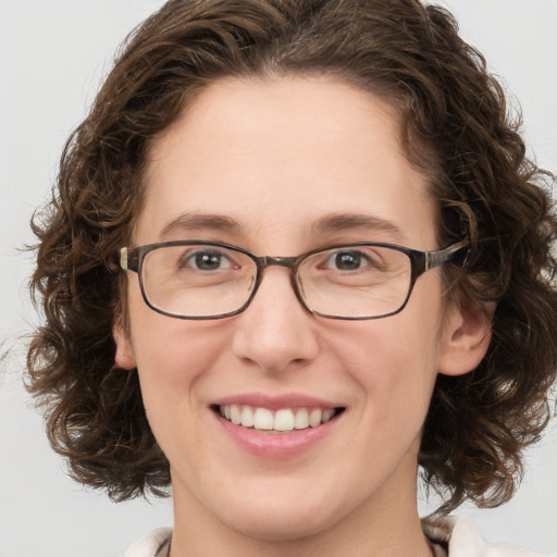 Joyful white adult female with medium  brown hair and green eyes