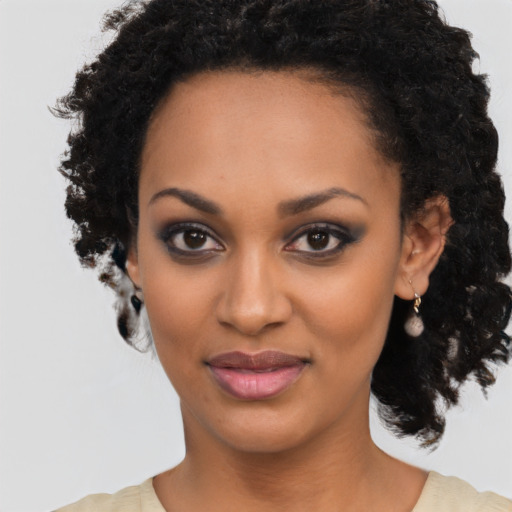 Joyful black young-adult female with medium  black hair and brown eyes