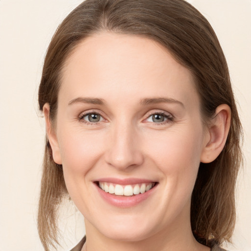 Joyful white young-adult female with medium  brown hair and grey eyes